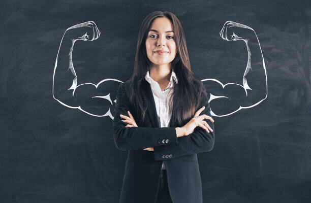 Portrait of attractive young european businesswoman with drawn muscly arms. Confidence and power concept