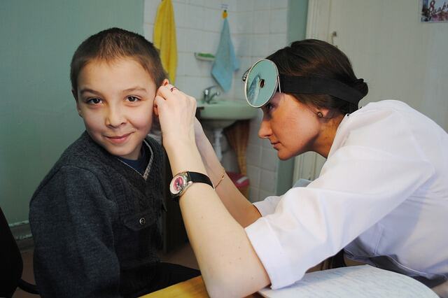 Ent doctor inspecting ear - representing health check ups