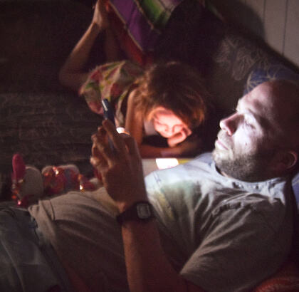 Father on his phone illuminates his face - screen time
