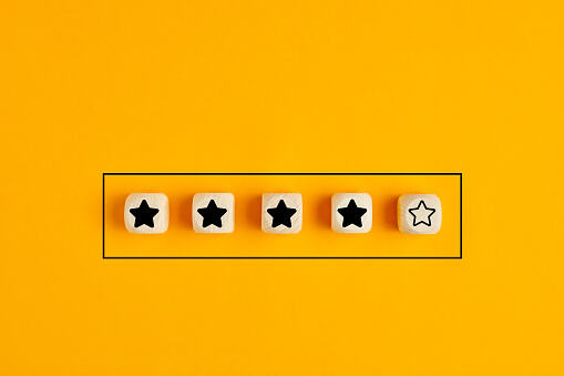 Wooden cubes with four stars out of five. Concept of service rating and evaluation.