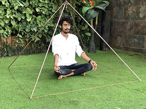 Man doing yoga under the Copper Meditation Pyramid