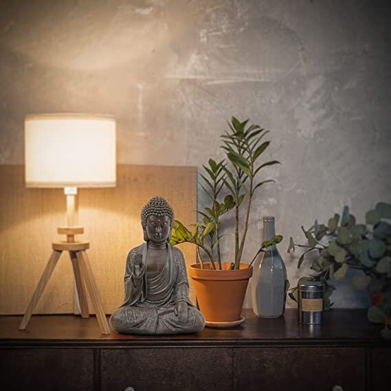 buddha statue next to a lamp