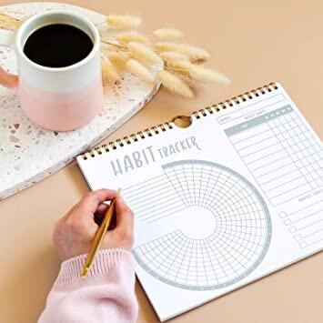 Habit Tracking Calendar with coffee and hand