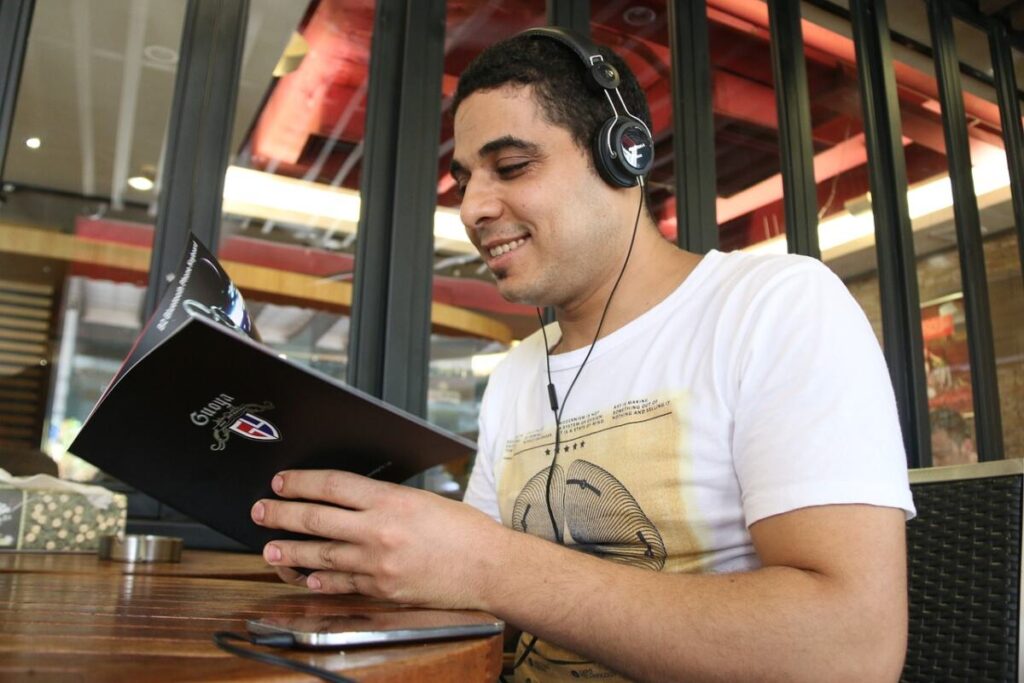 Man sitting with headphones - Listen to music in a foreign language