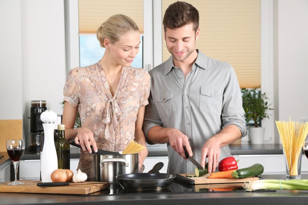 couple cooking in the kitchen - Buy A Cookbook And Try Making Every Meal