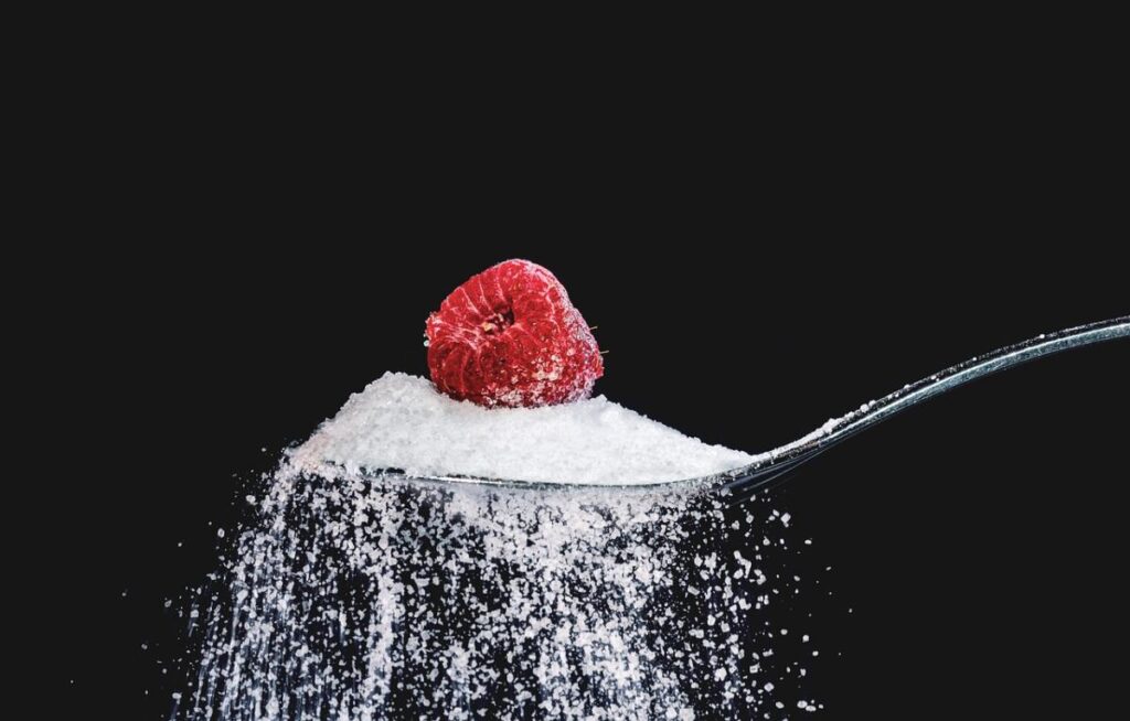 Sugar and Raspberry on spoon - Cutting Back On Sugar