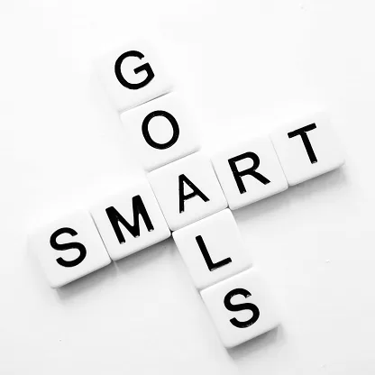 Words smart and goals in crossword style in black lettering on white tiles